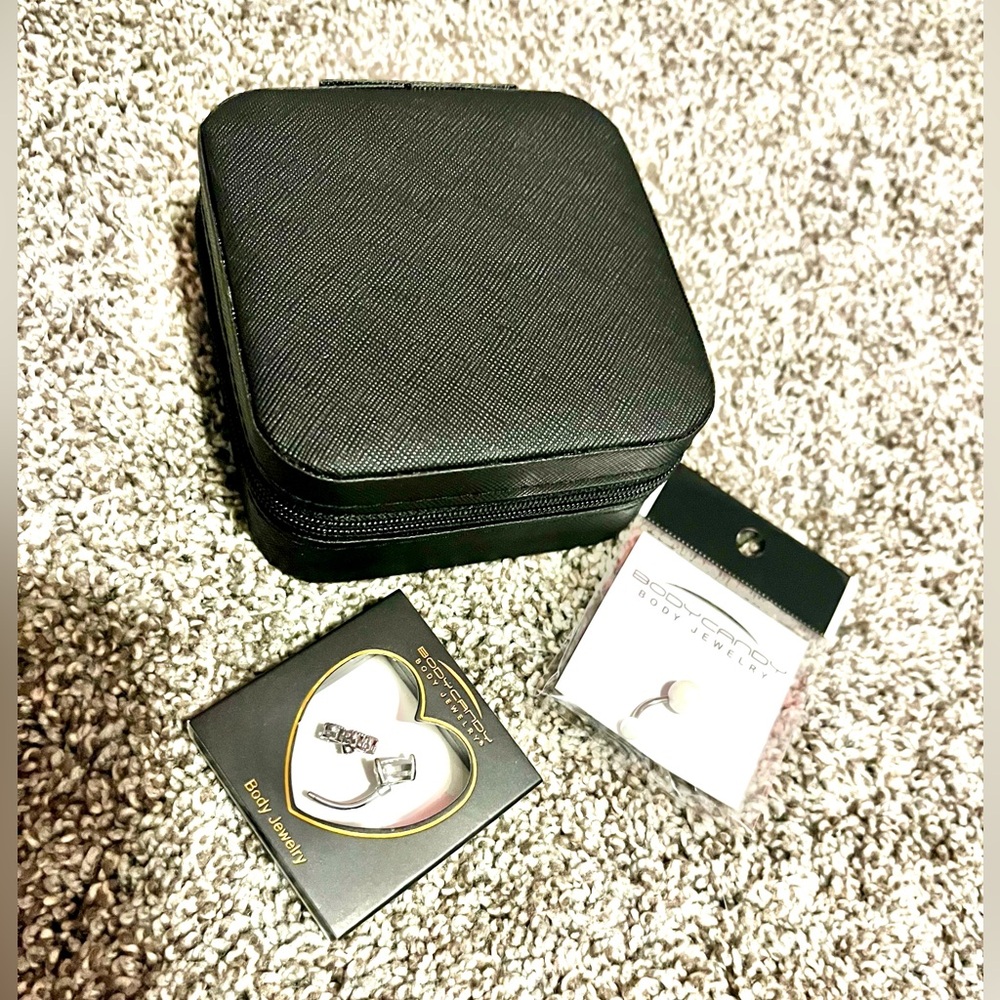 Two belly rings and carrying case brand new from body candy.